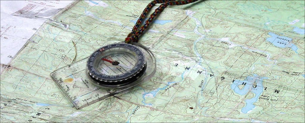 Compass lying on top of a map