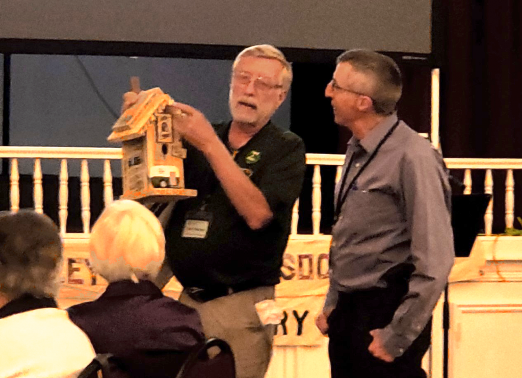 Ian Bailey receives the 2023 Volunteer of the Year award from Tom Friesen