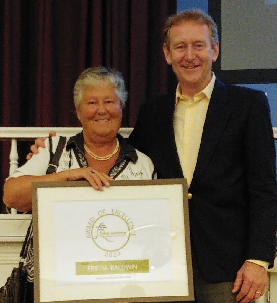 Frieda Baldwin holding her Award of Excellence certificate, standing with Hike Ontario president Mike Bender